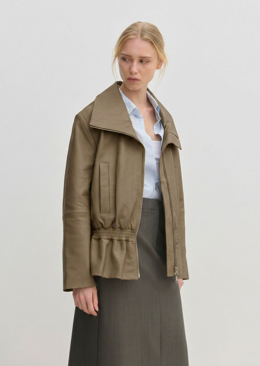 Sully Leather Jacket by Herskind ApS in olive green lamb leather with an oversized funnel neck and a smocked, elasticized waist.