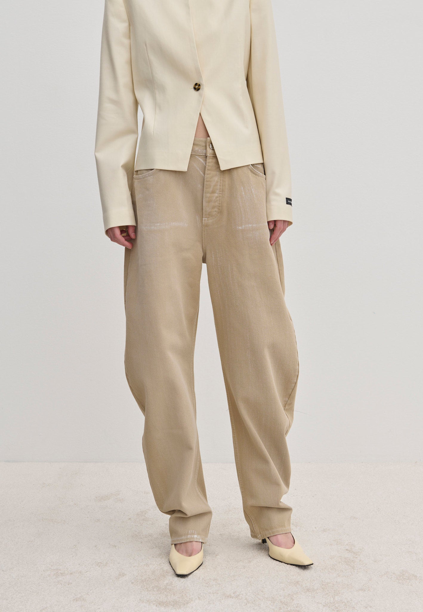 Relaxed-fit, beige Freya Denim Jeans (30 - Short) in a barrel-leg style with a faded wash, paired with a cream blazer and pointed-toe heels.
