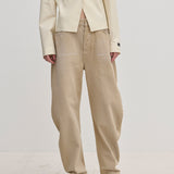 Relaxed-fit, barrel-leg tan Freya Denim Jeans (32 - Long) by Herskind ApS worn with a cream-colored button-up jacket and pointed-toe heels.