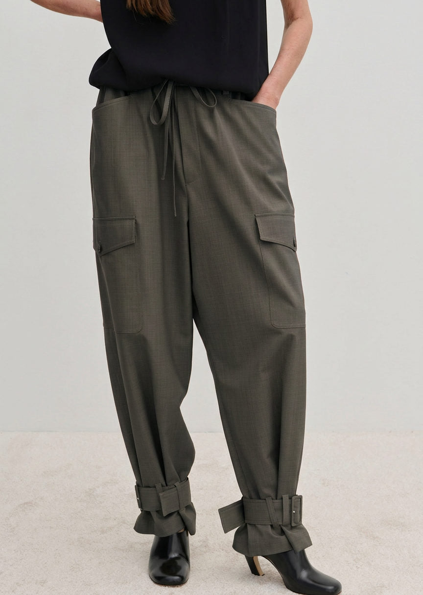 Olive green Maddie Mid waist Baggy Pants with a relaxed, baggy fit, featuring a drawstring waist, side pockets, and buckled straps at the ankles.