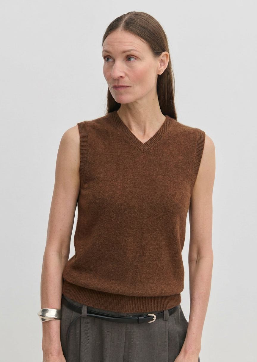 A woman wearing a brown V-neck Herskind ApS Fabien Knit Vest.