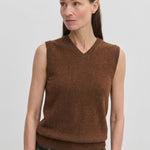 A woman wearing a brown V-neck Herskind ApS Fabien Knit Vest.