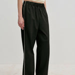 Davi Mid waist Pants by Herskind ApS in black with a white side stripe and a comfortable elasticated waistband.
