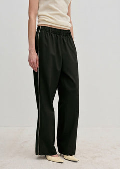Davi Mid waist Pants by Herskind ApS in black with a white side stripe and a comfortable elasticated waistband.
