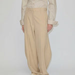 Beige mid-waist barrel leg Dante Mid Waist Pants with a relaxed fit, worn with a button-down shirt.