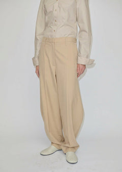 Beige mid-waist barrel leg Dante Mid Waist Pants with a relaxed fit, worn with a button-down shirt.