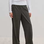 Person wearing dark gray Pinky Mid waist pants with a wide-leg fit and a white long-sleeved shirt.