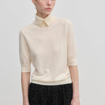 Cream-colored Perry Knit Blouse by Herskind ApS, featuring short sleeves and a pointed collar in merino wool.