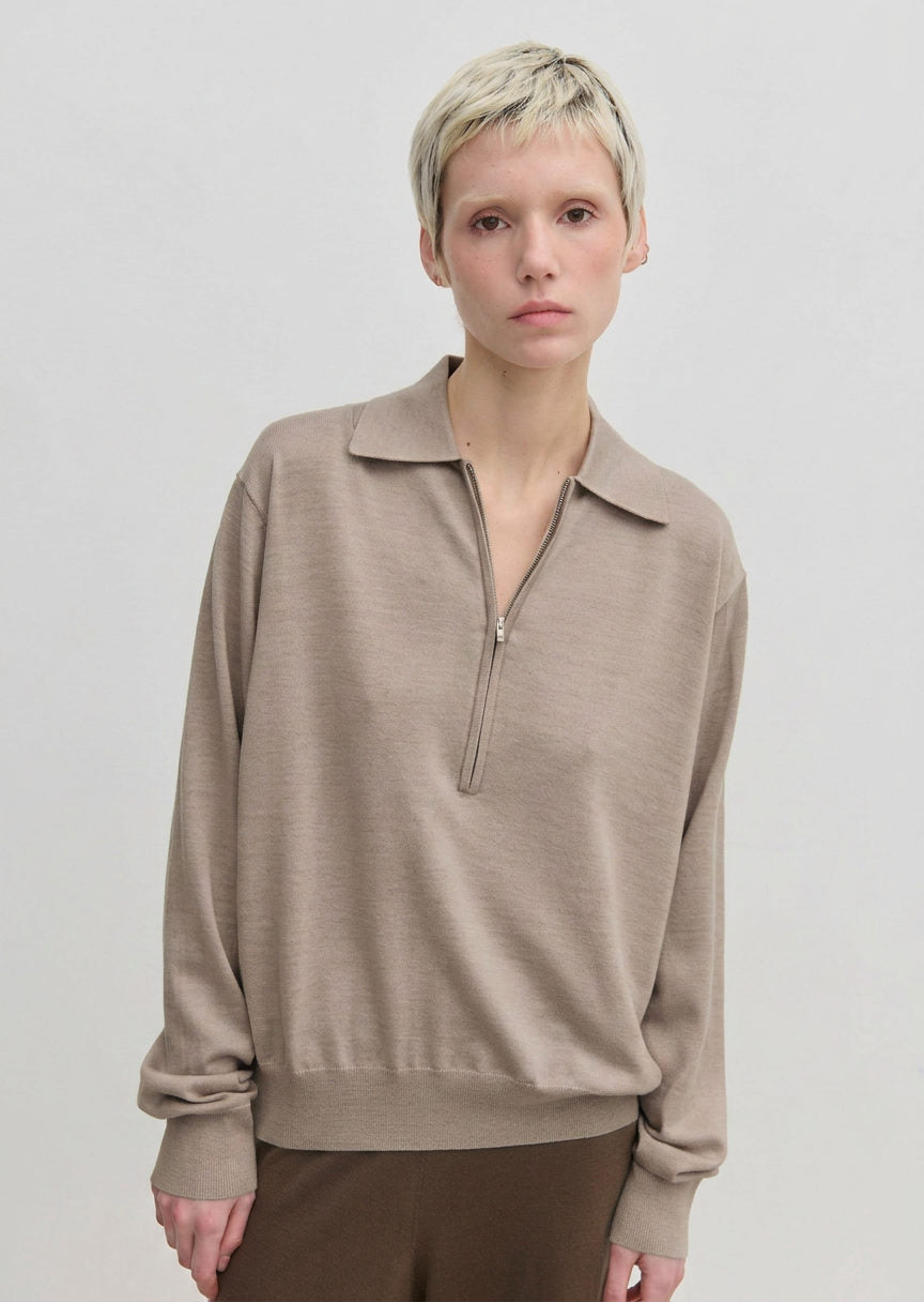 An Agatha Knit Blouse by Herskind ApS in beige, fine-gauge knit featuring a classic collar and a partial front zipper.