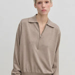 An Agatha Knit Blouse by Herskind ApS in beige, fine-gauge knit featuring a classic collar and a partial front zipper.