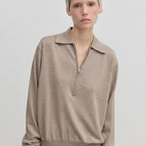 An Agatha Knit Blouse by Herskind ApS in beige, fine-gauge knit featuring a classic collar and a partial front zipper.