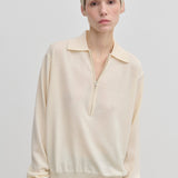 Agatha Knit Blouse by Herskind ApS in a cream-colored fine-gauge knit with a half-zip neckline.