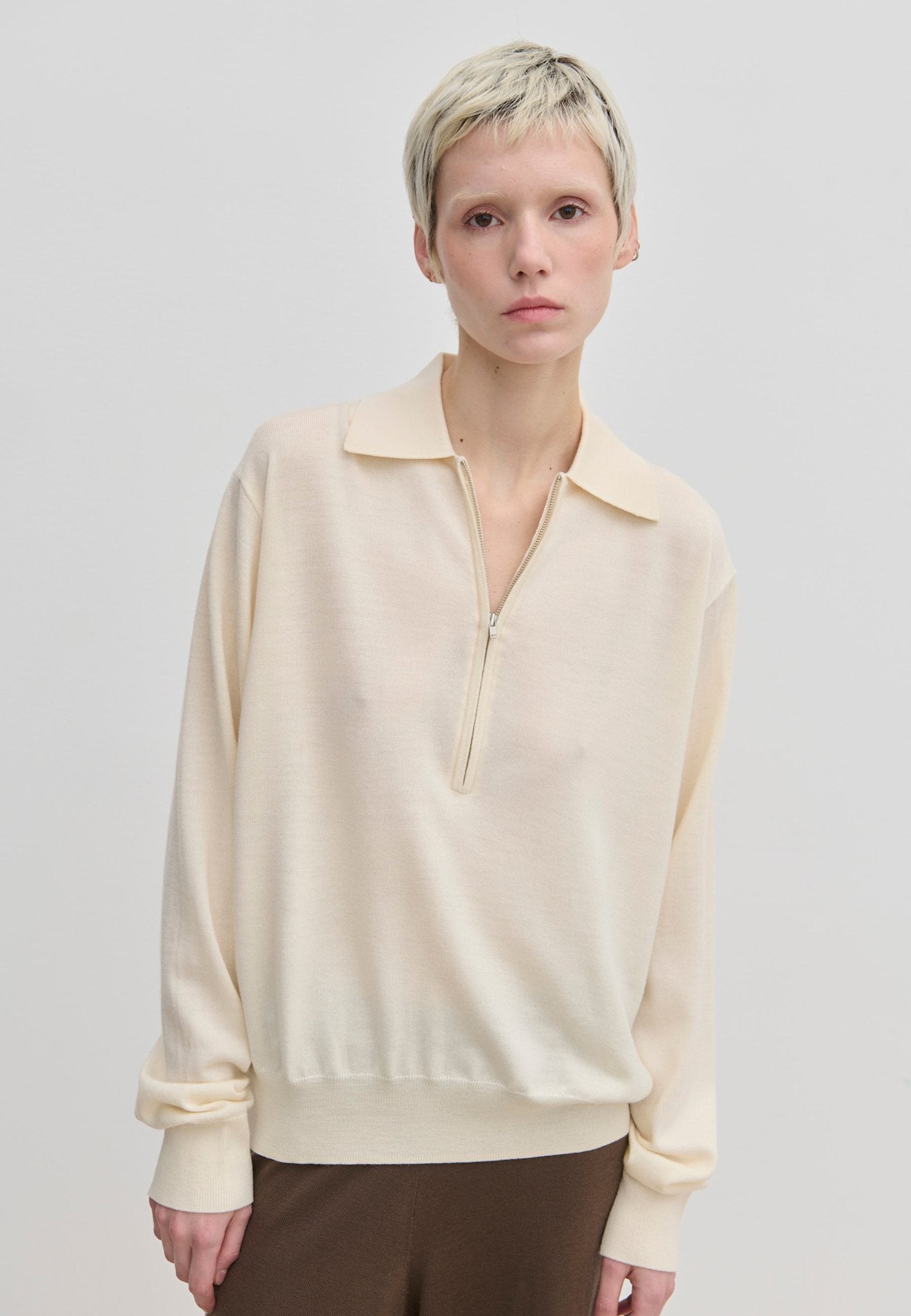 Agatha Knit Blouse by Herskind ApS in a cream-colored fine-gauge knit with a half-zip neckline.