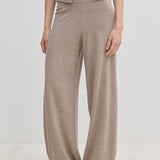 A person wears beige Clark Knit Pants and a matching cardigan over a white top.