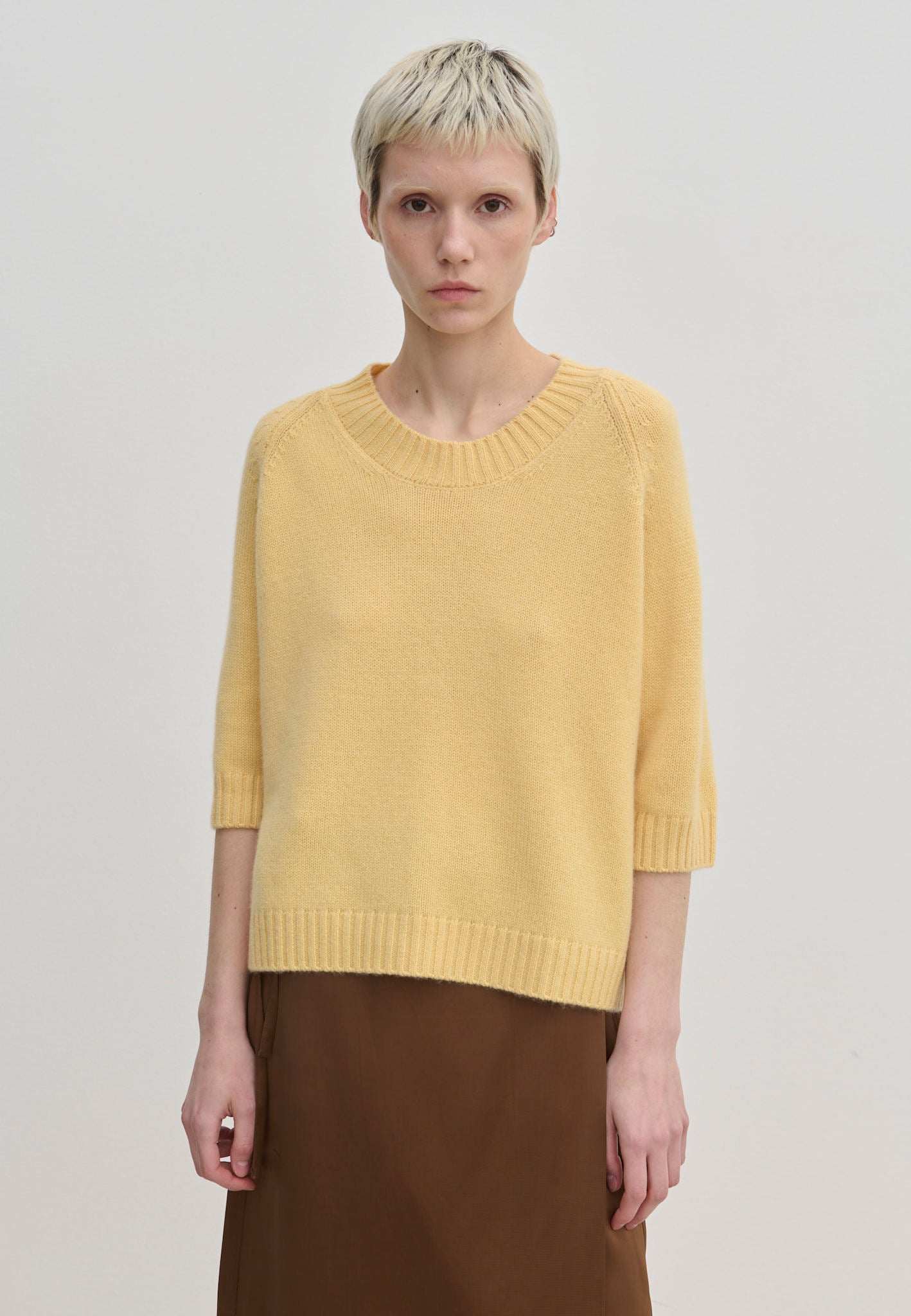 A pale yellow, short-sleeved Josie Cashmere Knit Blouse by Herskind ApS with a crew-neck knit.