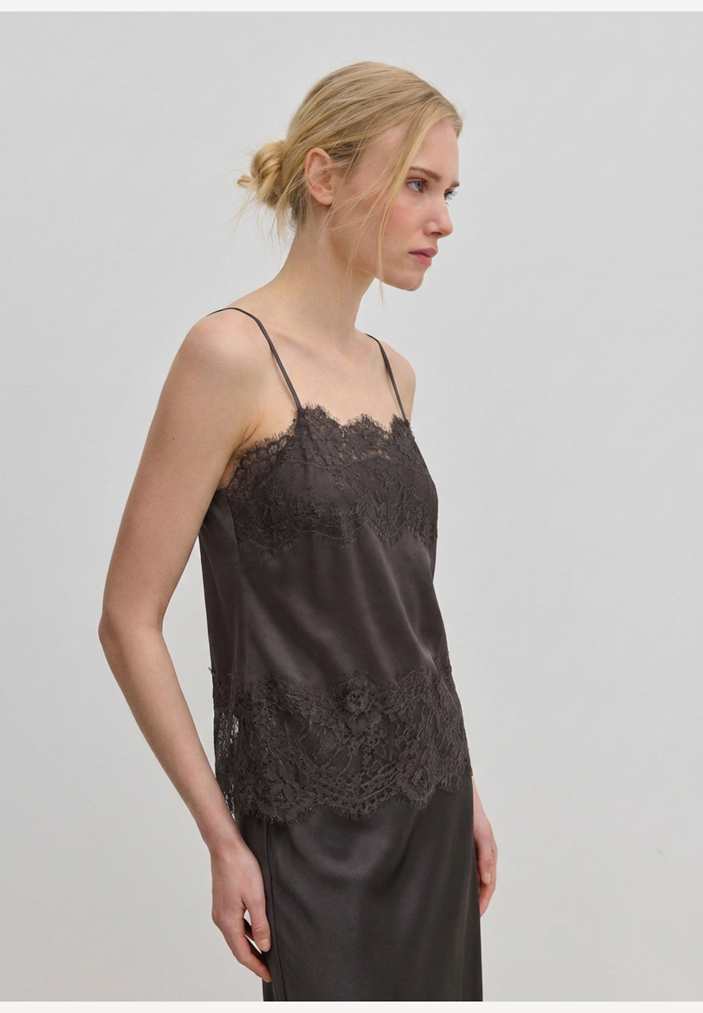 Herskind ApS Linnea Top in dark grey, featuring adjustable straps and lace trim along the neckline and hem.
