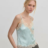 The Herskind ApS Little Top is a pale blue camisole with adjustable straps and wide beige lace trim along the neckline and hem.