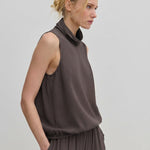 The Herskind ApS Loa Top is a sleeveless, brown FSC viscose top featuring a high, draped cowl neckline and a gathered hem.