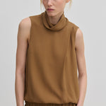 The Herskind ApS Loa Top is a sleeveless brown garment in a relaxed fit with a high, draped cowl neckline.