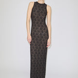 A person wearing the Herskind ApS Chris Dress, a floor-length, sleeveless black lace maxi dress over a nude lining.