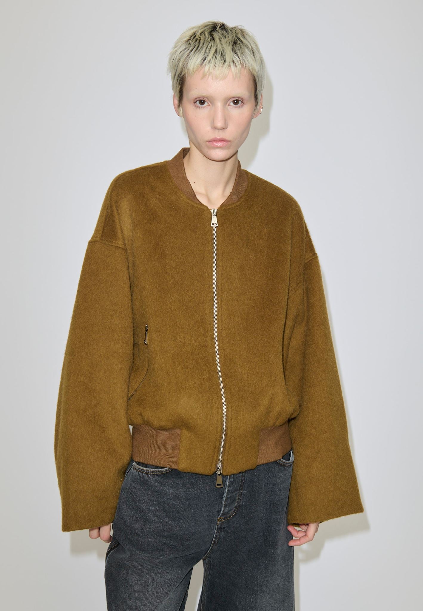 A model wearing the Herskind ApS Monica Bomber Jacket, a cropped wool and alpaca design with a zip-up front and a ribbed collar and waistband.