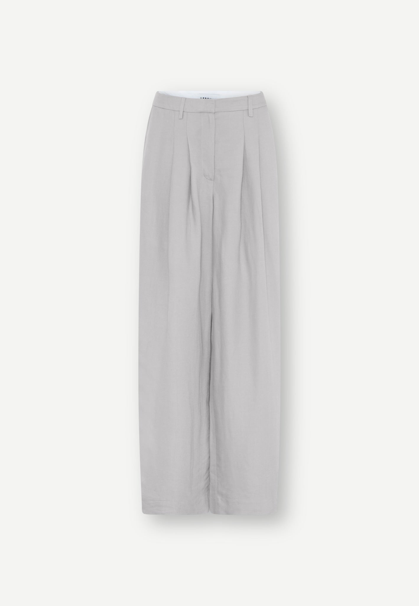 Relaxed-fitted Lotus Pants - Stone in light gray linen with front pleats and a button-fly closure.